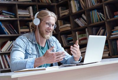 An online student, using a laptop, talking with their tutor in English.