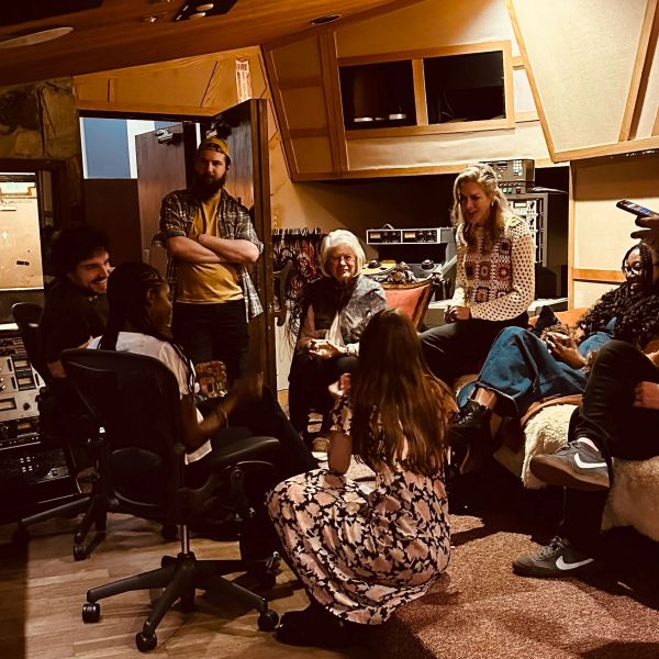 Group chatting in a cozy recording studio.
