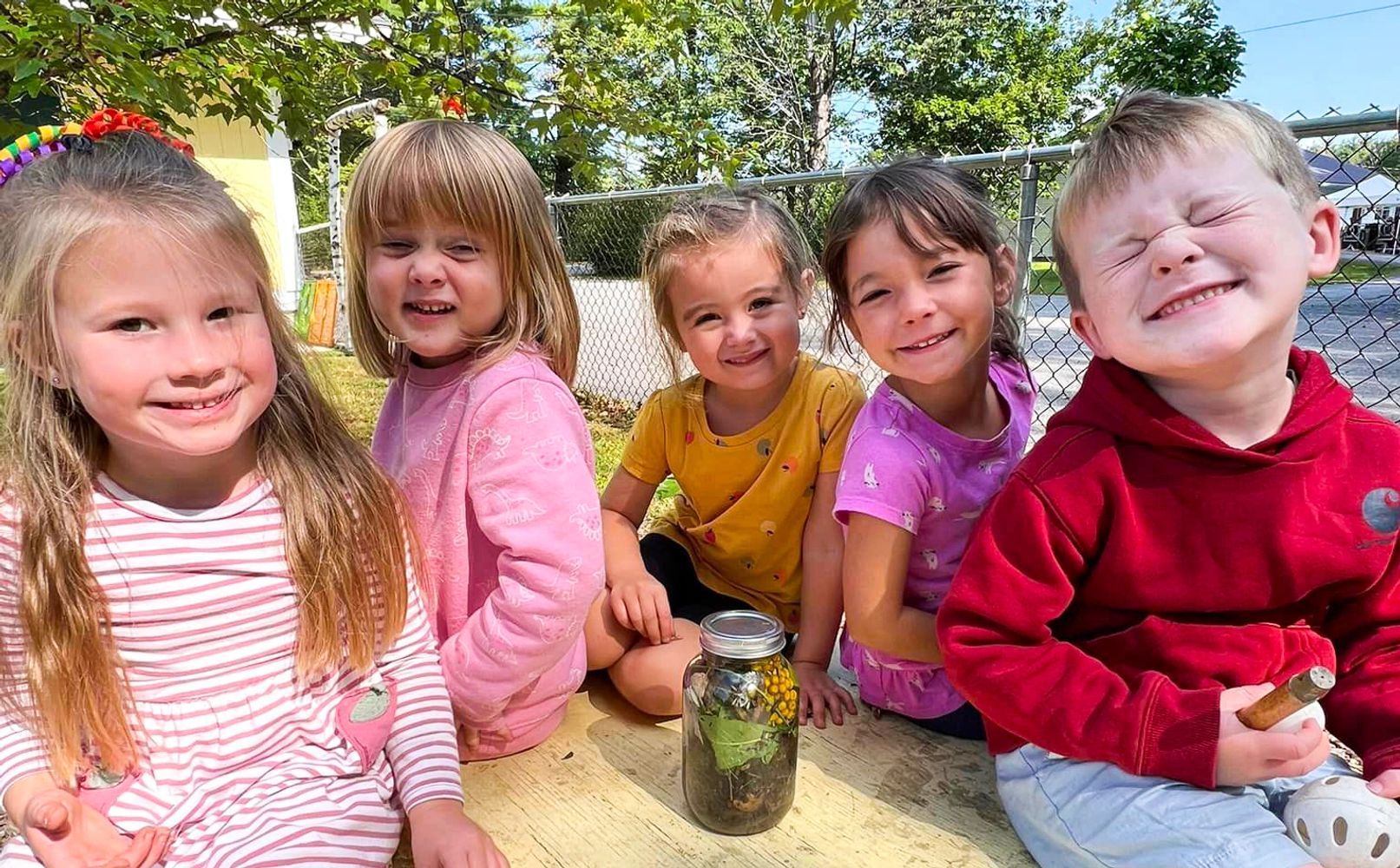 Group of kids smiling at picnic table
