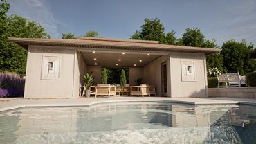 Modern poolside cabana with seating and lush greenery.