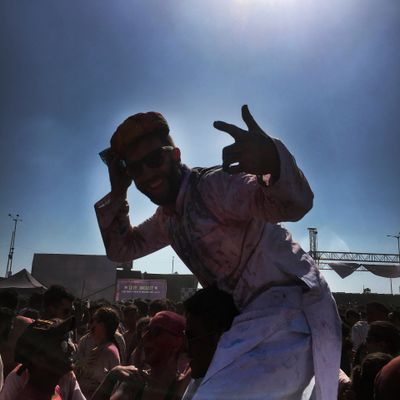 Person enjoying a sunny outdoor event with crowd around.