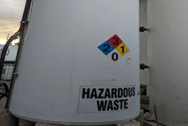 Large tank labeled hazardous waste with safety ratings.