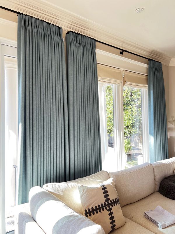 Sunlit living room with blue curtains and beige sofa.