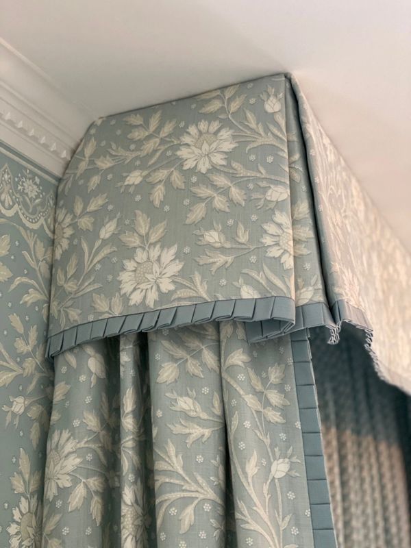 Floral patterned curtain with a decorative valance in soft blue and cream tones.