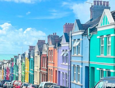 Colorful row of Victorian-style houses under a bright blue sky.