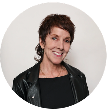 Smiling woman with short hair and black leather jacket.