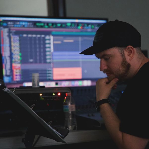 Brian Martinez Music Producer Reading music score for orchestral recording session. 