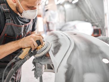 A professional polishing a car