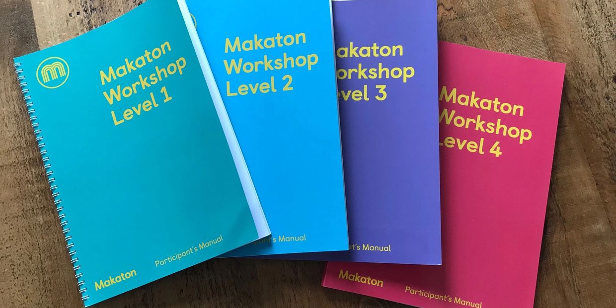 Photograph of four Makaton Workshop Participants' Manuals.