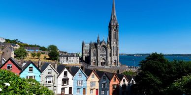Colorful houses with a large Gothic church and blue sky in the background.