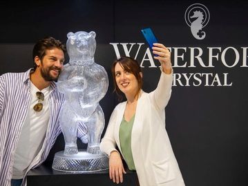 Two people take a selfie next to a crystal bear sculpture at Waterford Crystal.