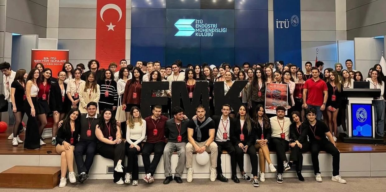 Large group of students posing in front of ITU Endüstri Mühendisliği Kulübü banner.