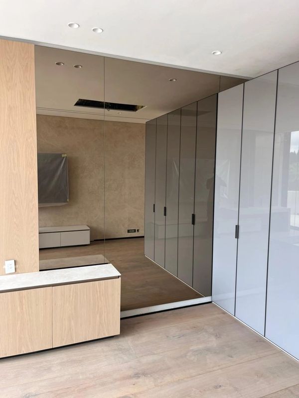 Modern room with sleek wardrobes and wooden cabinetry.
