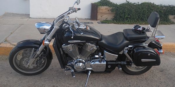 Black cruiser motorcycle parked on a street with chrome details.