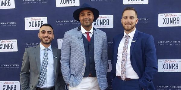 Three men in suits posing at a California Western School of Law event.
