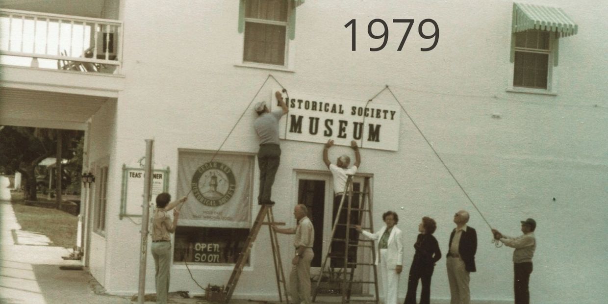 People fixing a board with the help of a ladder