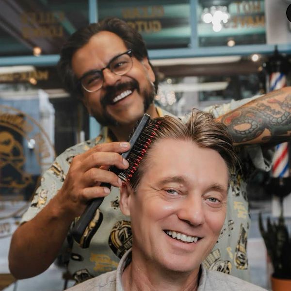 Barber styling a happy customer's hair.