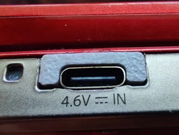 Close-up of a USB-C charging port labeled 4.6V IN on a red device.