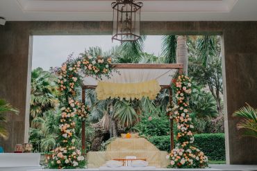 Floral arch and decorated wedding altar with greenery.