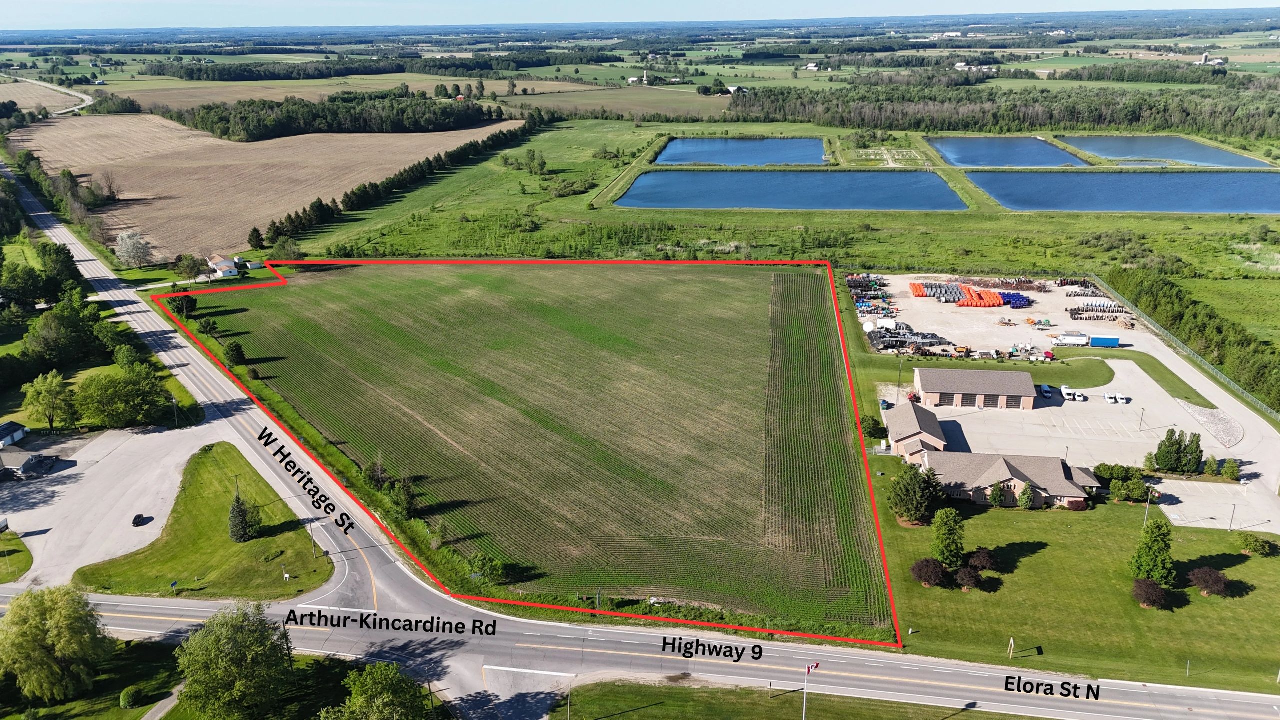 Aerial view of farmland bordered by roads and a water area.