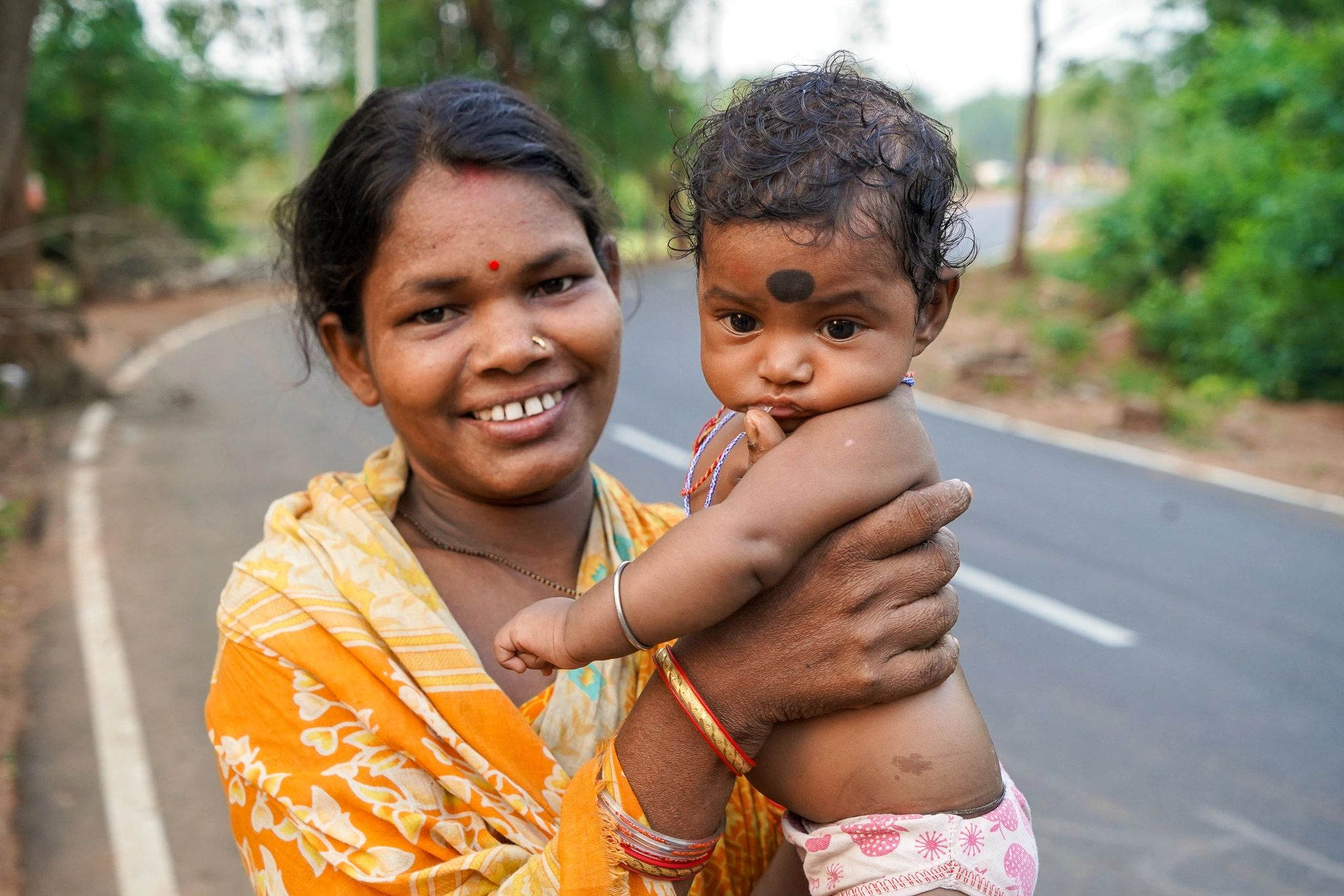 Smiling tribal woman holds her child