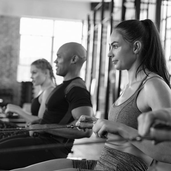 People working out together on rowing machines in a gym.