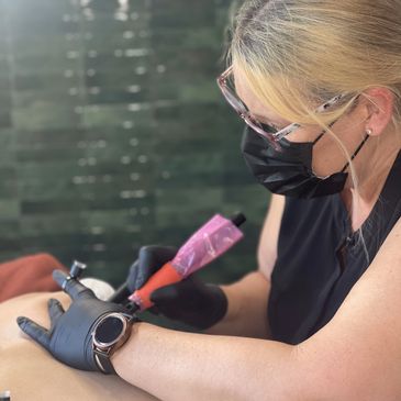 DeeDra Cornelius applying Advance ISR Inkless tattoo technique on a client's skin.