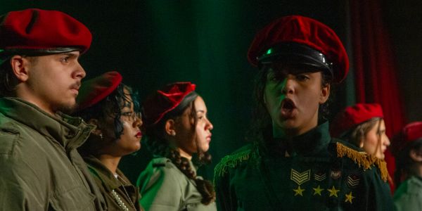 Grupo de pessoas com boinas vermelhas em uniforme.