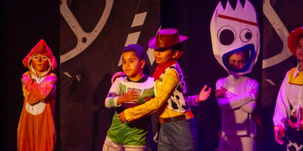 Crianças vestidas com fantasias de personagens de Toy Story.