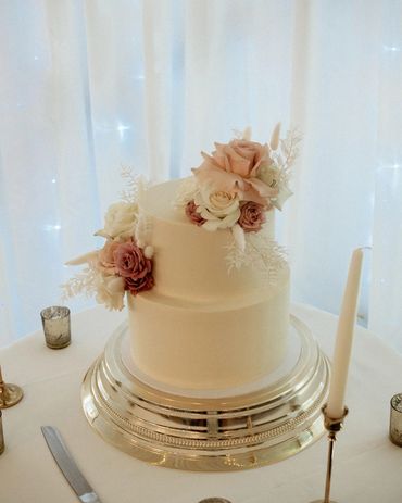 two tier boho cake surrounded with gold candles.