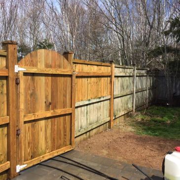 Fence pressure washing in progress showing the difference between cleaned and uncleaned surfaces in 