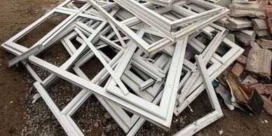 Stack of removed uPVC window frames from window installation job in Bolton ready for collection. 