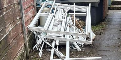 Pile of removed uPVC window frames ready for recycling collection in Bury 
