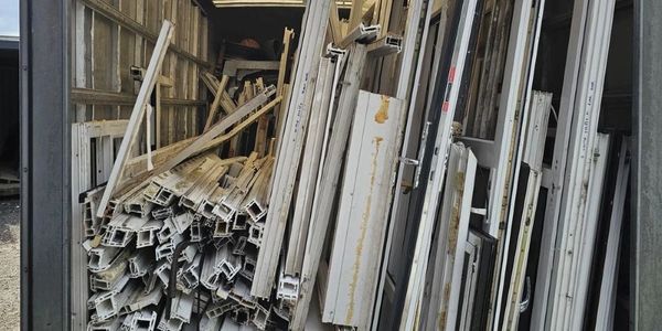 Fully loaded van transporting commercial uPVC window frames for recycling 
