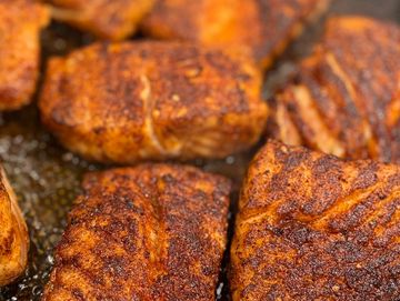 Close-up of seasoned, grilled chicken pieces.