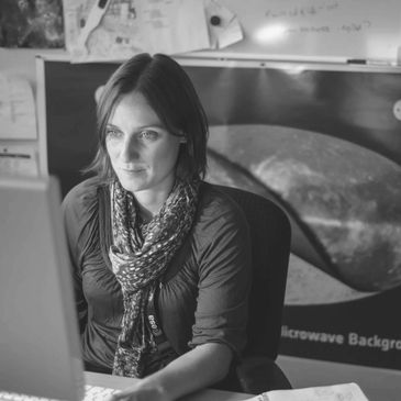A lady sitting in front of a desktop computer