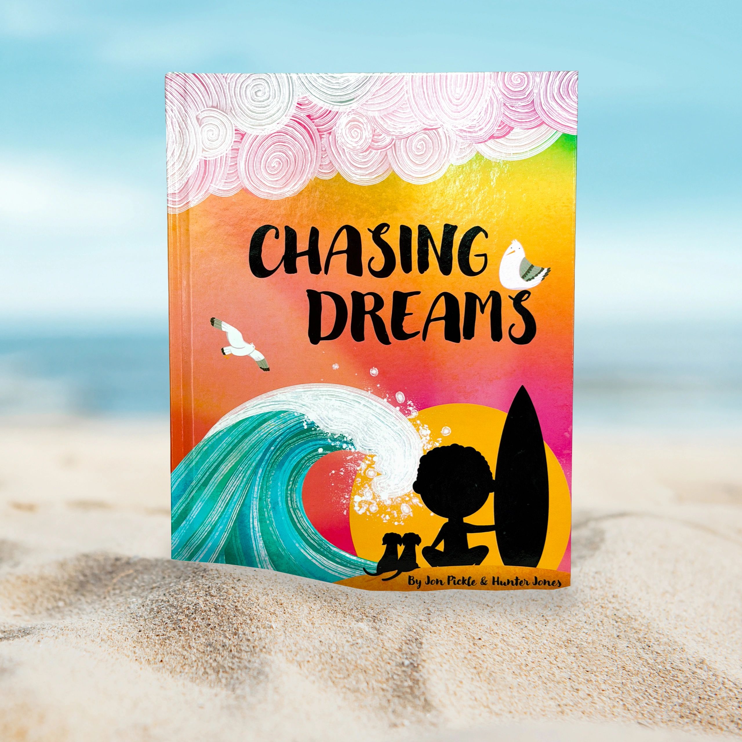 Colorful book cover titled "Chasing Dreams" with ocean waves and silhouetted figures.