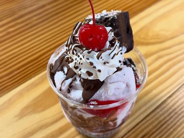 Chocolate sundae with whipped cream and cherry.