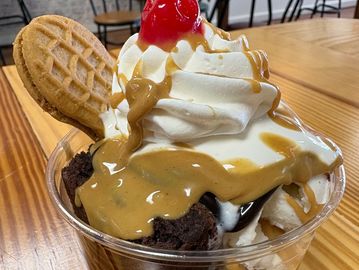 Ice cream sundae with whipped cream and cherry.