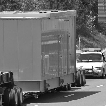 Truck with oversize load followed by a pilot car that is functioning as a chase car. 