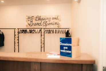 Donation box on counter under a grand opening sign.