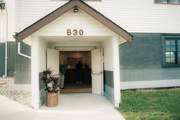 Entrance to a building numbered 830 with people inside.