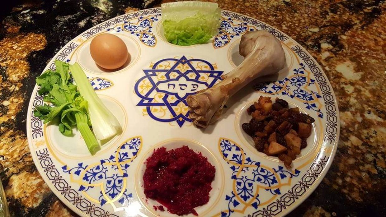 Seder plate with traditional Passover symbolic foods on a decorative platter.