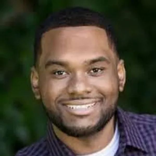 Smiling man with a beard and short hair.
