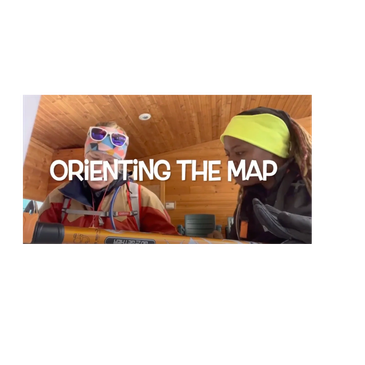 Two people indoors orienting a map together.