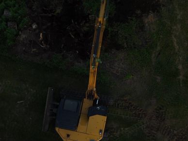 Aerial view of a yellow excavator at work.