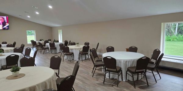 Empty event room with round tables and chairs.
