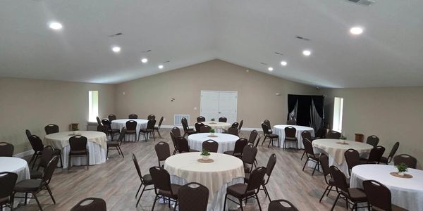 Empty event room with round tables and chairs.