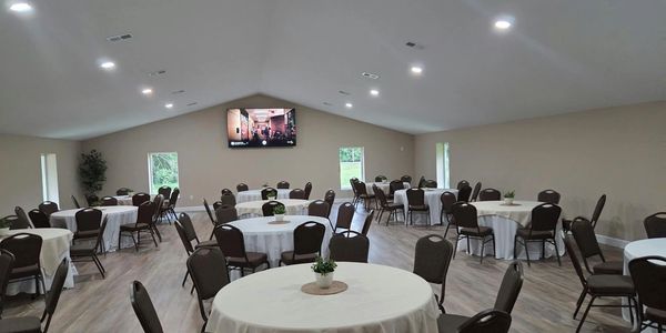 Empty event room with round tables and chairs.
