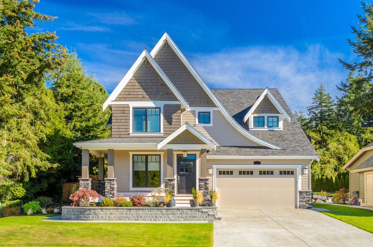 Modern two-story suburban house with garage and well-maintained garden.